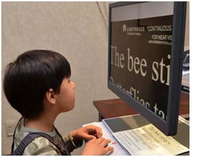 Sehbehinderte Junge liest mit Bildschirmlesegerät
